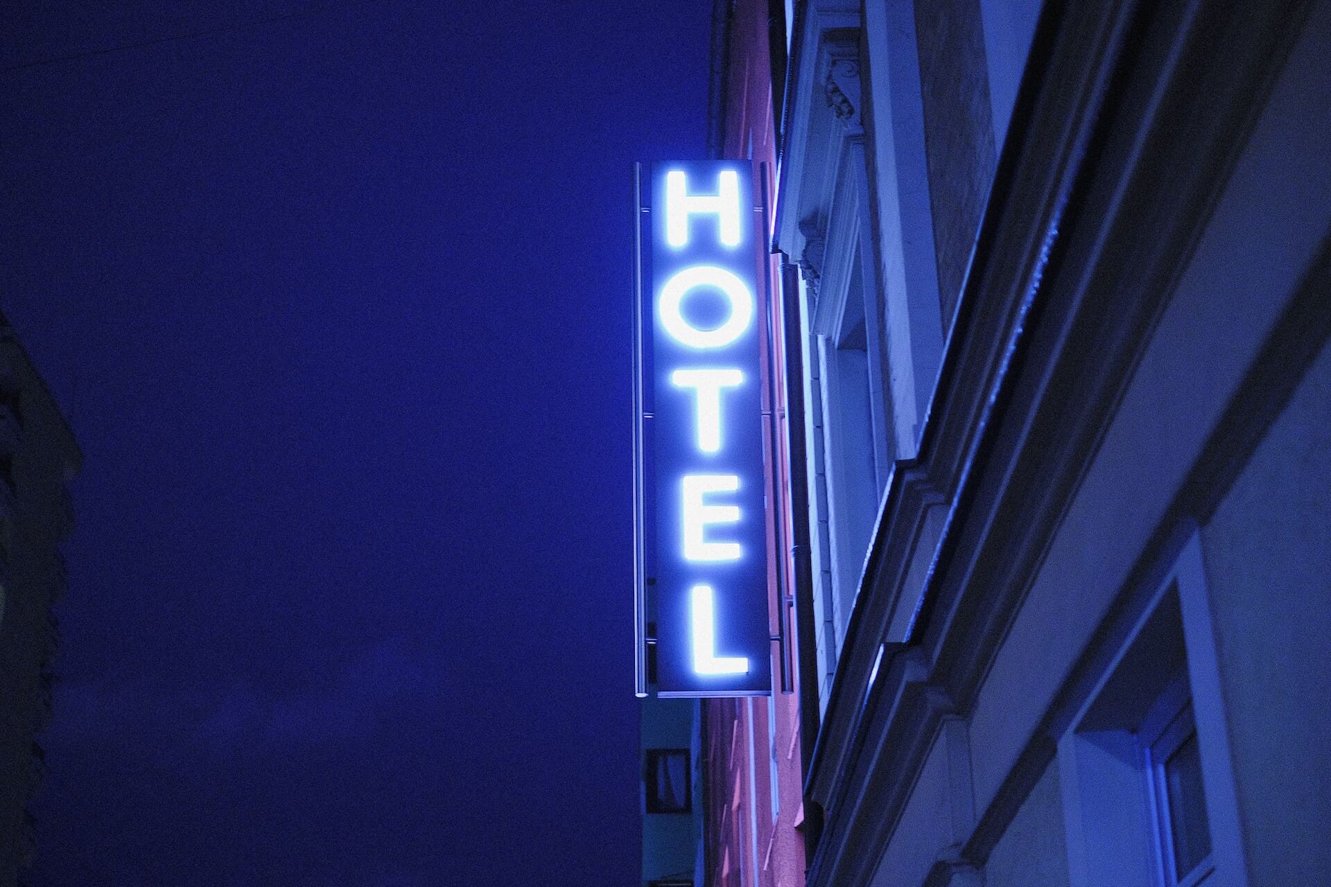 Photo of a luminous hotel sign with the word 'Hotel' in bright letters